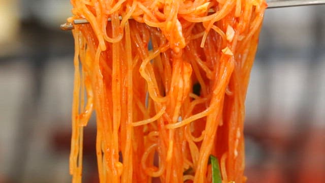 신선한 채소가 들어간 먹음직스러운 비빔쫄면 한 젓가락