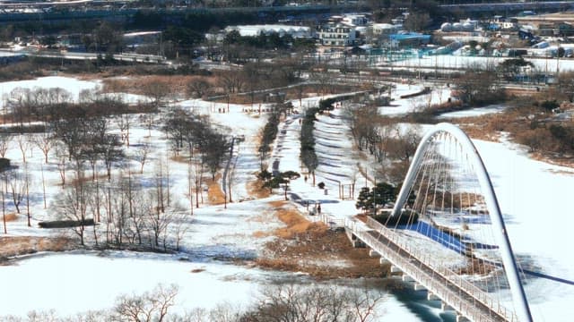 Snow-covered Park with Arched Bridge