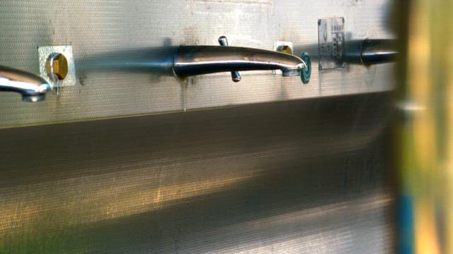 개수대의 수도꼭지로 플라스틱 용기에 물을 받는 모습