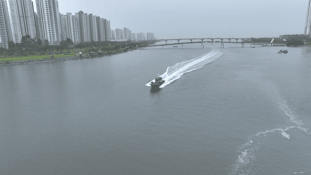 A boat speeding on a river in the city