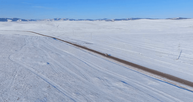 Snowy landscape with a road and cars