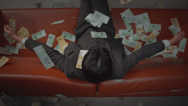 소파에 앉은 남자 위로 내리는 현금