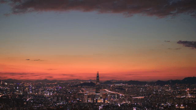 Cityscape with colorful lights and tall towers at sunset