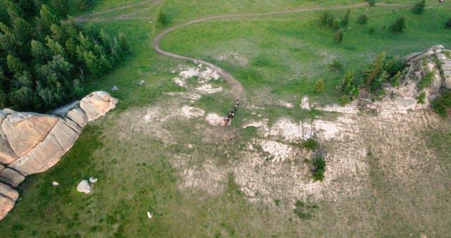 Riders on a trail through a green landscape