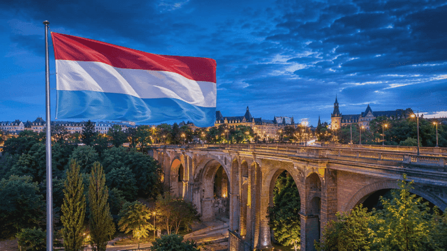 Luxembourg cityscape with a flag at dusk