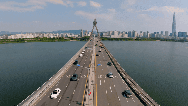 높은 도시 풍경이 보이는 강 위의 다리 도로