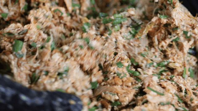 Hands mixing dumpling filling ingredients