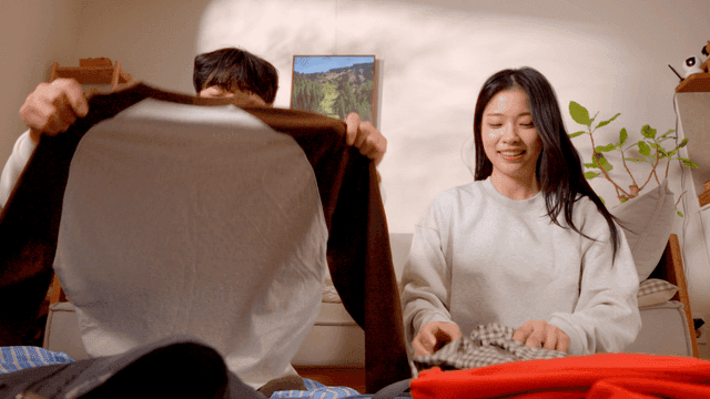 Couple folding clothes together in living room
