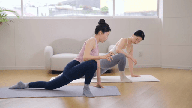 Pilates instructor guiding a student indoors