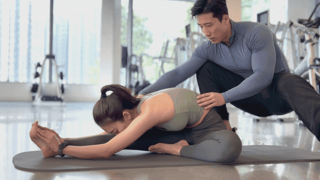 트레이너와 함께 스트레칭을 하는 여성
