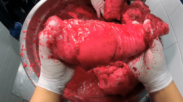 돼지 다리에 비트를 갈은 소스를 버무리는 모습