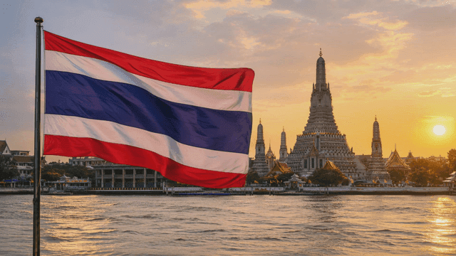 Thai flag at sunset and riverside temple