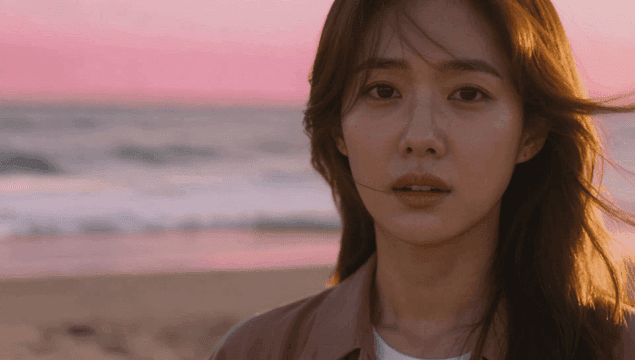 해질녘 해변에 서 있는 젊은 여성