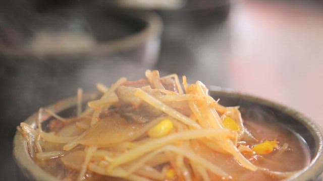 Green onion on top of beef and rice soup