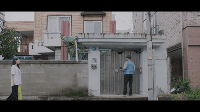 주택 대문 앞의 배달원과 여성