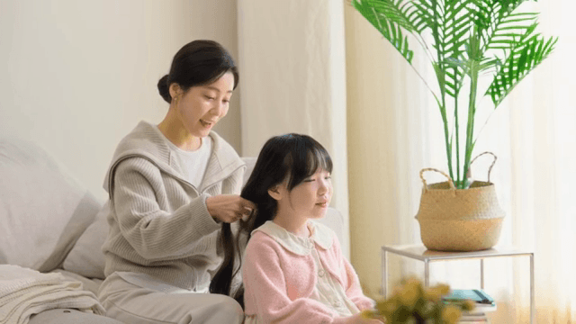 엄마가 딸의 머리를 땋아주는 모습