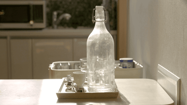 Glass bottles and cups on kitchen table