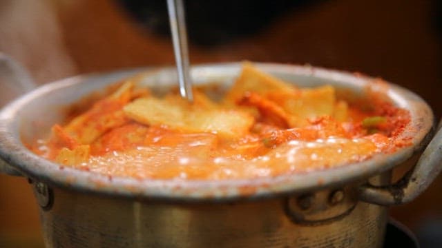 Chopstickful of fish cake of stew boiling in a pot