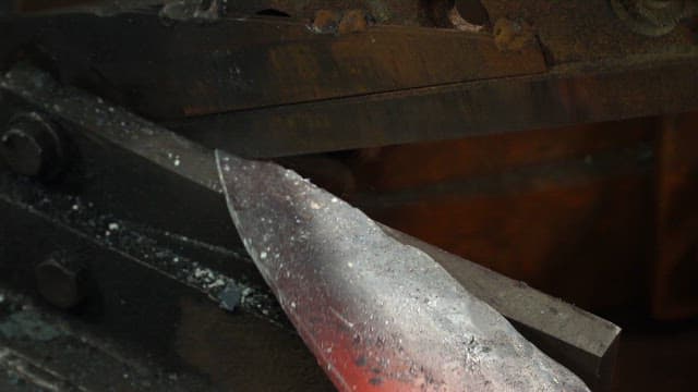 Heated metal blade being forged