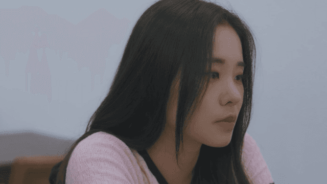 분홍 니트 상의를 입은 심각한 여성 옆모습