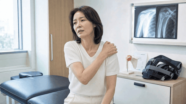 Female patient with shoulder pain in examination room
