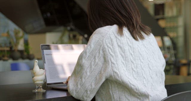 Studying at a Cafe with Ice Cream Next to Her