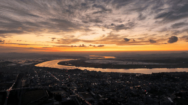 City skyline at sunset with a winding river