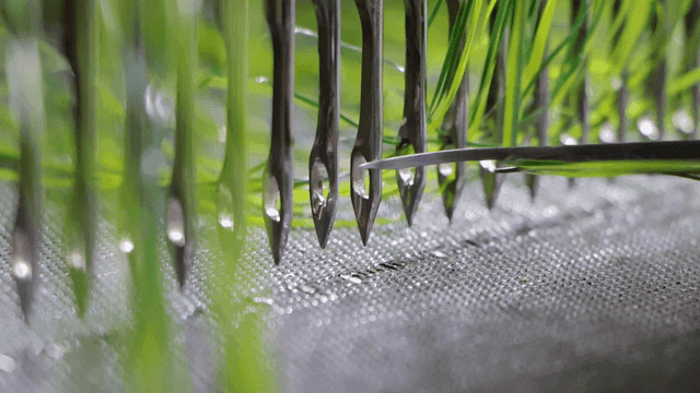 녹색 섬유들이 엮이고 있는 공장 베틀