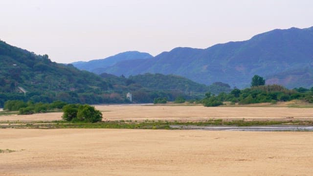 Expansive view of a scenic sand field with distant mountains