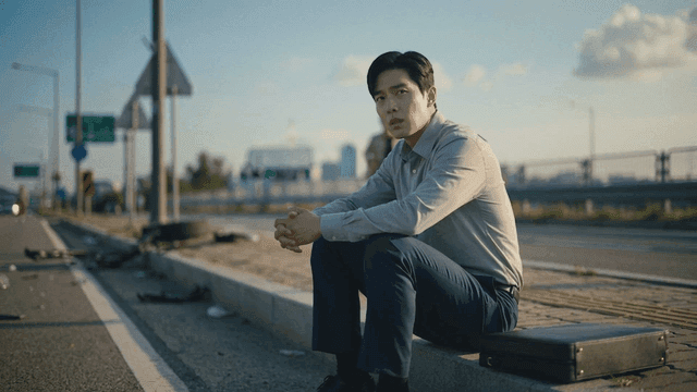 Man sitting on roadside with debris