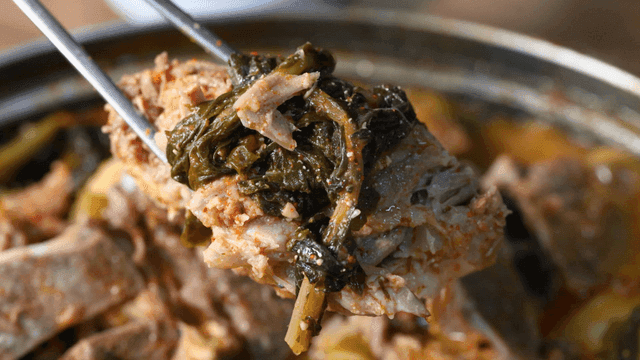 Gamjatang meat lifted with chopsticks