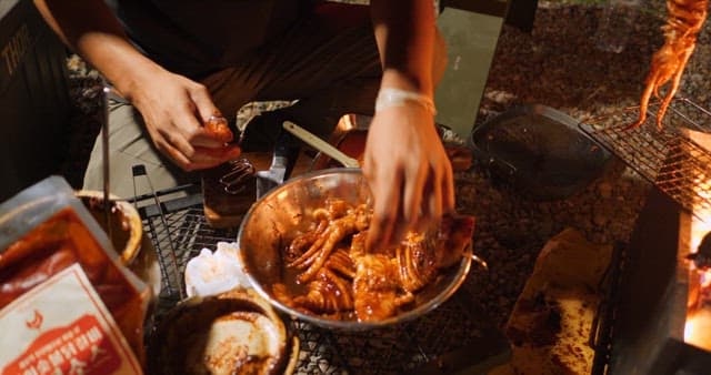 Person Preparing Food on an Outdoor Grill