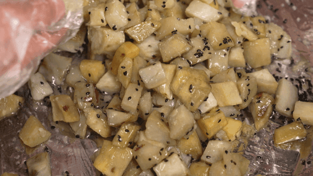 Sweet potato candy mixed with gloved hands