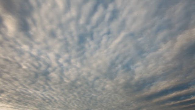 구름 낀 황혼의 하늘 아래 배가 정박된 해안 마을