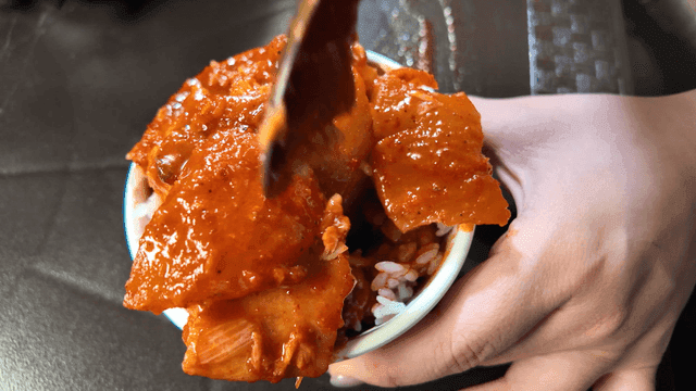 Spoonful of rice mixed with spicy braised fish