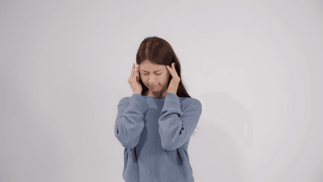 Woman holding her head with feeling headache and discomfort