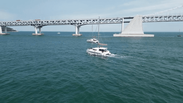 큰 다리 아래를 항해하는 요트