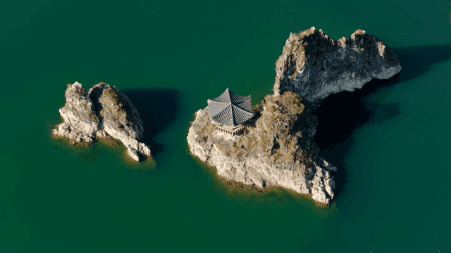 바위 섬 위의 전통 정자가 있는 호수