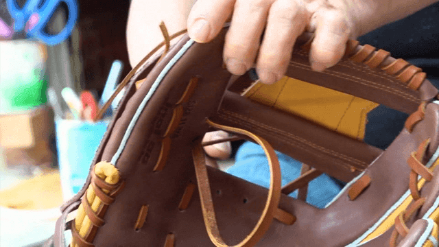 Artisan crafting leather baseball glove by hand