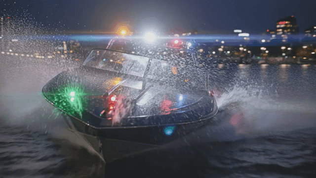Police boats speeding down river at night