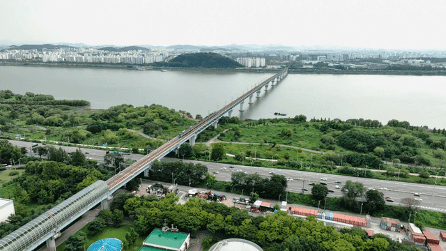 Bridges over river and trains running beneath city skyline