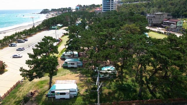 Coastal campsite with trees and caravans