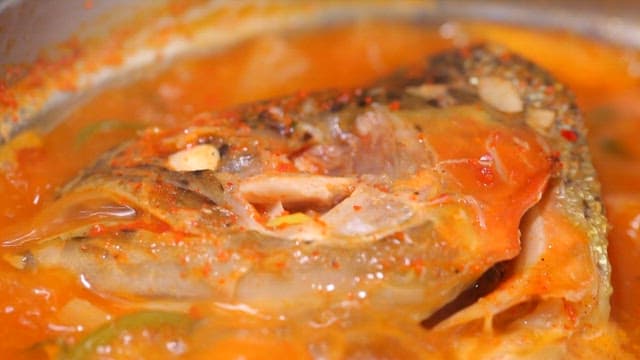 Spicy fish stew with trout boiling in a pot