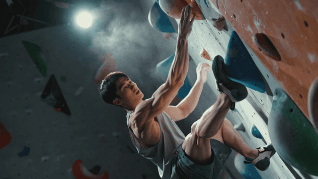 실내 암벽을 오르는 남성