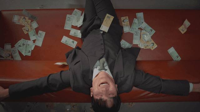 소파에 앉은 남자 위로 내리는 현금