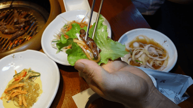 상추에 올려진 양념갈비와 야채 반찬들