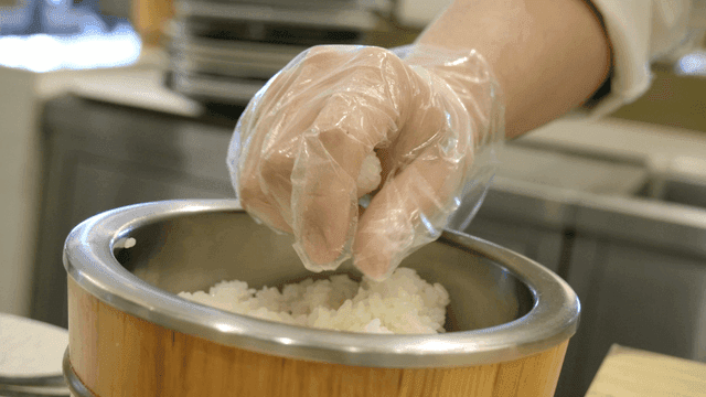 Chef shaping sushi in kitchen