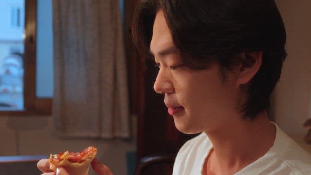 Person enjoying a slice of pizza indoors