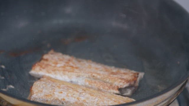 프라이팬에서 기름에 노릇노릇 구워지는 갈치