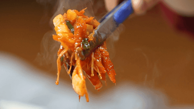 Steaming grilled burdock picked up with tongs